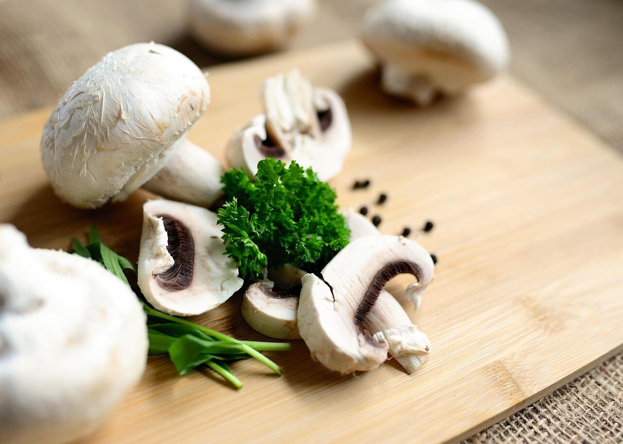 funghi Champignon affettati su un tagliere