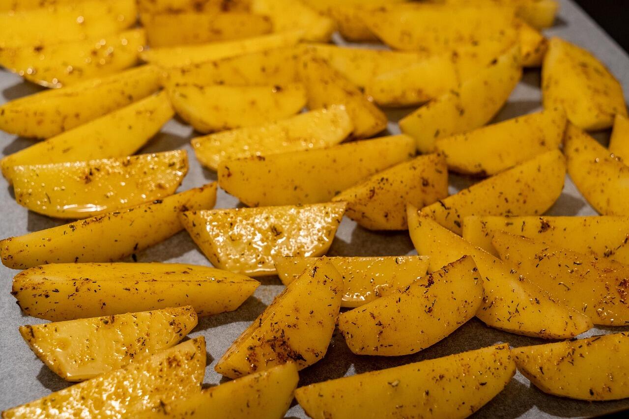 patate affettate crude e condite con spezie e aromi
