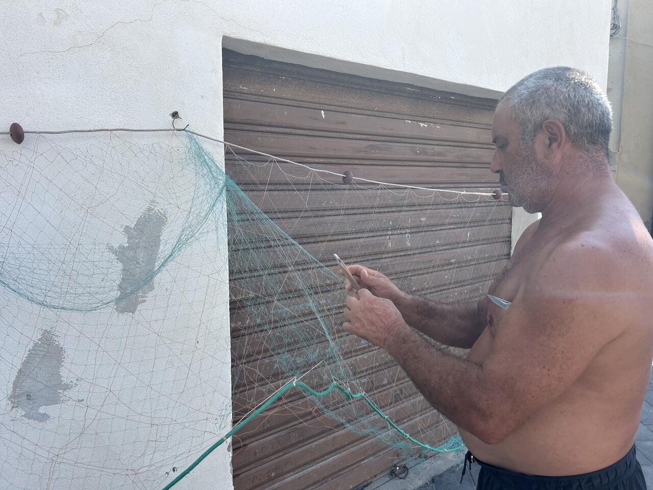 Pescatore di Fuscaldo Marina, sistema le reti per la pesca.