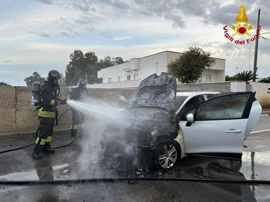 vigile spegne auto incendiata