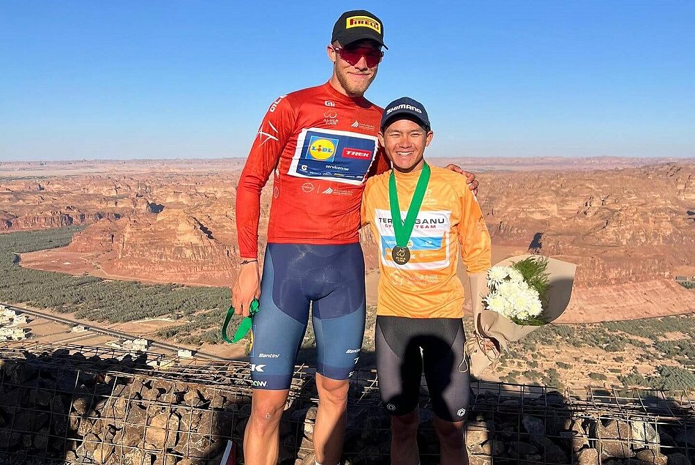 Kee Zhe Yie festeggia la maglia di corridore più combattivo dell'AlUla Tour, posando con Jonathan Milan