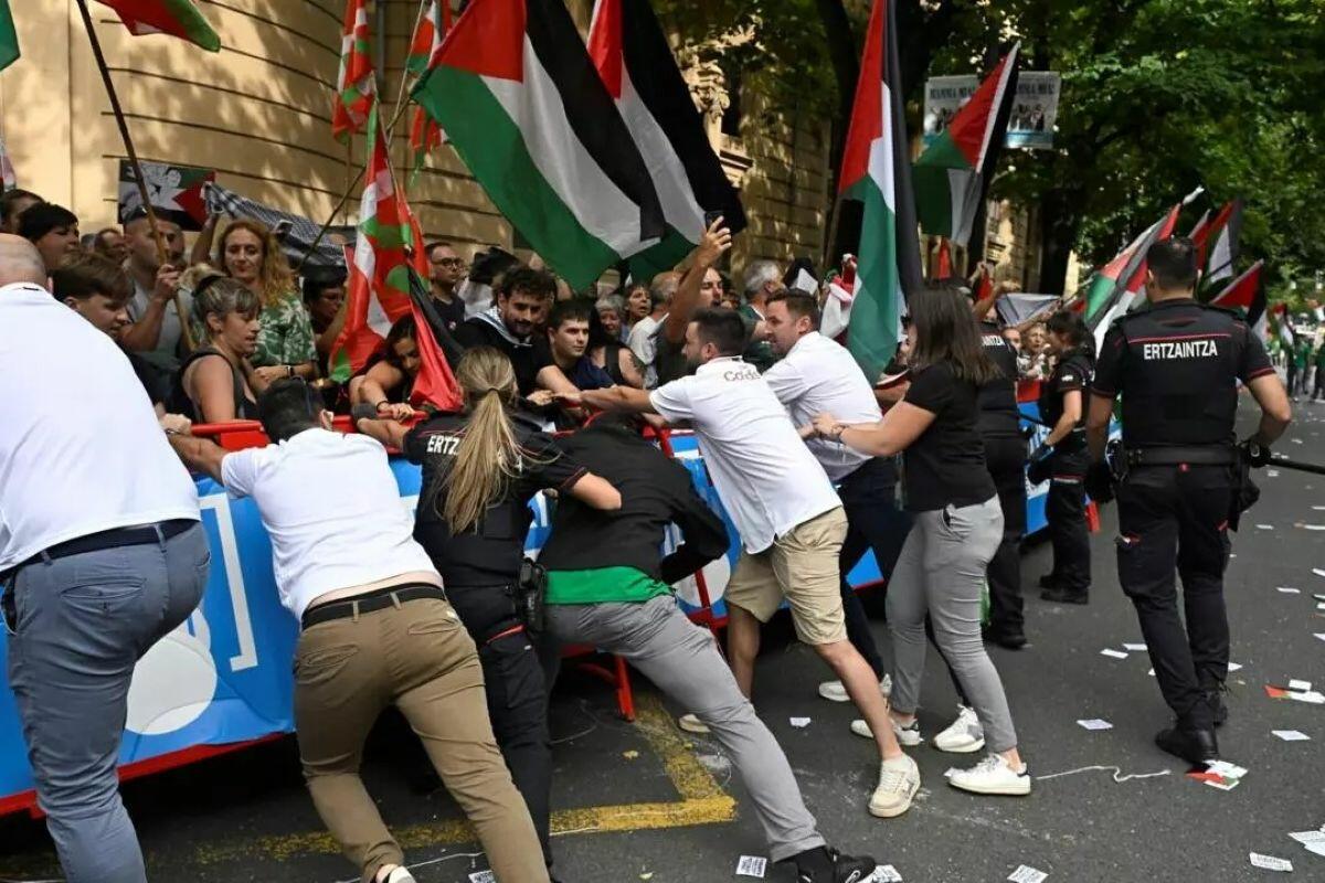 I membri dello staff e la polizia della Vuelta spingono via le barriere mentre i manifestanti filo-palestinesi manifestano al traguardo dell'undicesima tappa Bilbao ©ANDER GILLENEA / AFP